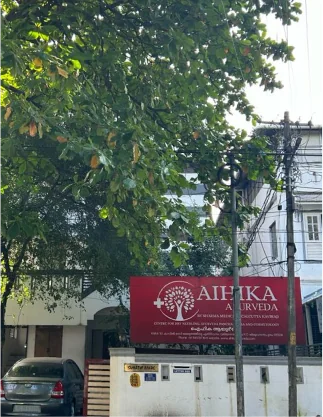 Aihika Ayurveda clinic exterior beneath a leafy tree